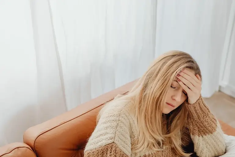 Nő fejét fogja fibromyalgia krónikus fájdalom miatt.